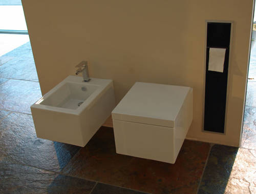 Simas Frozen WC wandh�ngend wei� art. FZ18 und Frozen Bidet wandh�ngend wei� art. FZ19,  kombiniert mit Gessi Rettangolo Armaturen chrom, im Hintergrund ein Asis Modul mit versteckter WC B�rstengarnitur und Rollenhalter, zu sehen in der B�derausstellung Sanikal Brixen